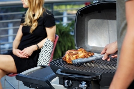 TravelQ-PRO285X-lifestyle-girl-in-background-food-Napoleon-grills